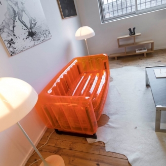 Надувной диван прозрачного оранжевого цвета в интерьере комнаты